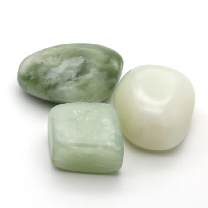 China-Jade Hellgrüne Serpentin-Jade (China-Jade) Trommelsteine auf weißem Hintergrund.