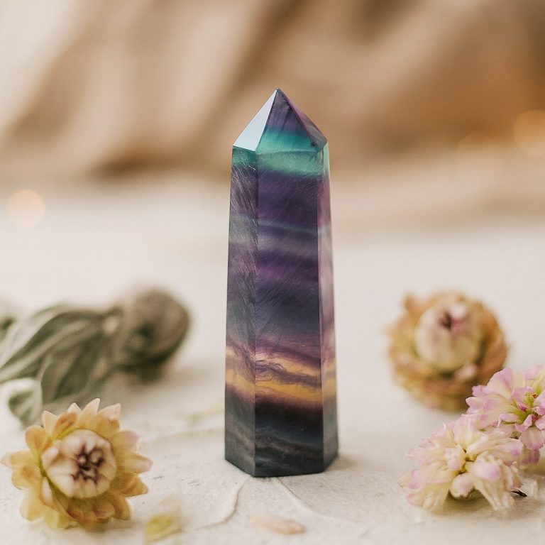 Fluoritspitze mit Blüten – stimmungsvolles Stillleben in sanften Naturtönen, Symbol für die Themenwelten von Sandras Mineralien.